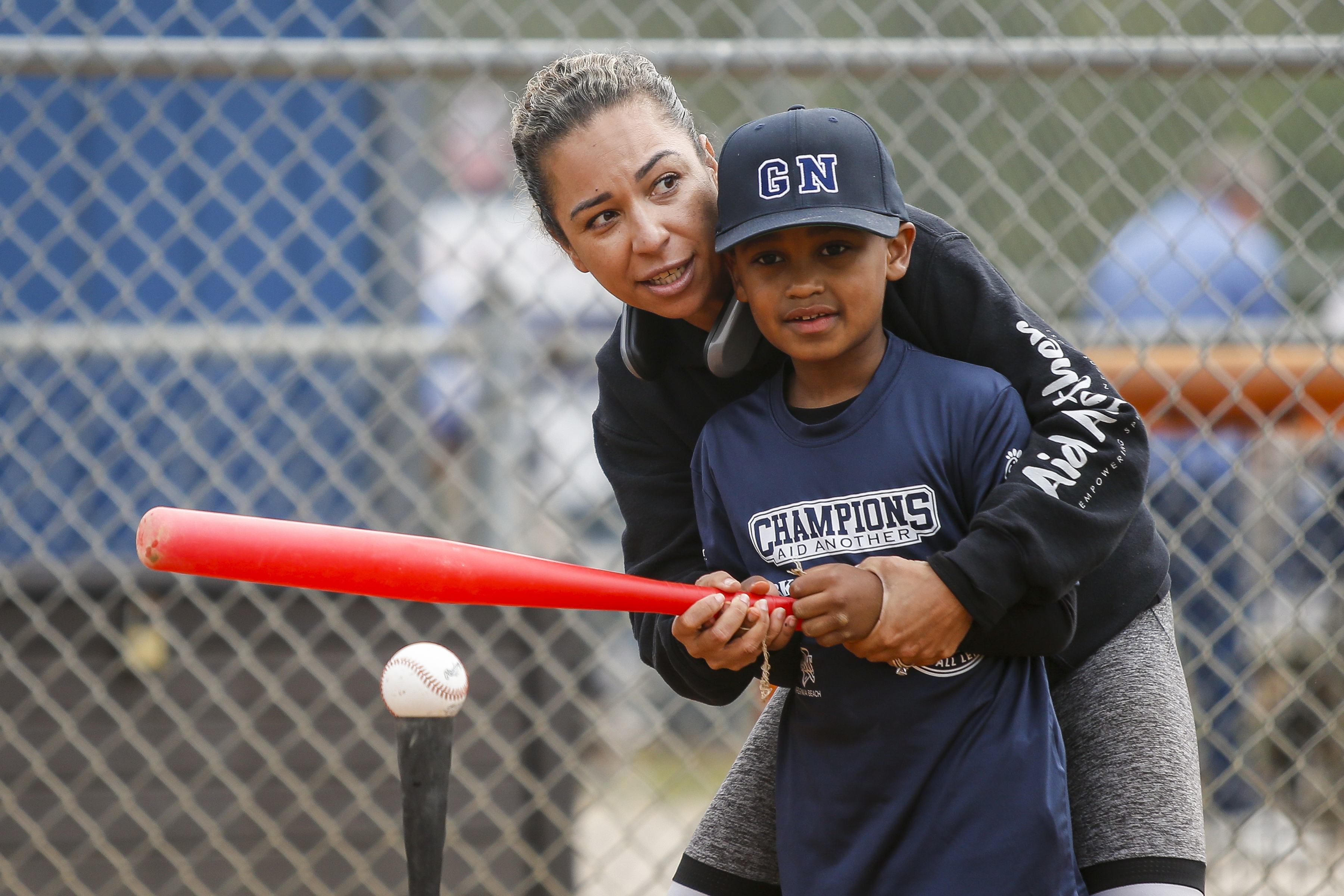 Christine Ross assists Derrell Willis Jr during his at-bat in...
